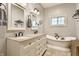 Bathroom featuring double sink vanity, soaking tub, and neutral decor at 5829 Broadway St, Indianapolis, IN 46220