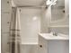 Bright bathroom featuring white subway tile, vintage vanity, and bathtub with shower at 5829 Broadway St, Indianapolis, IN 46220