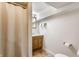 Bathroom featuring modern vanity with lighting, shower with curtain, and vinyl flooring at 5829 Broadway St, Indianapolis, IN 46220