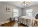 Cozy bedroom with hardwood floors, complemented by natural light streaming through two bright windows at 5829 Broadway St, Indianapolis, IN 46220