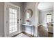 A welcoming entryway with a modern table, round mirror, and an arched doorway at 5829 Broadway St, Indianapolis, IN 46220