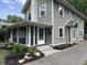 Side view of the home with a screened porch, showcasing the architectural details and landscaping at 5829 Broadway St, Indianapolis, IN 46220