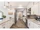 A modern kitchen with white cabinets, stainless steel appliances, granite countertops, and stylish backsplash at 5829 Broadway St, Indianapolis, IN 46220