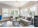Bright living room featuring large windows, comfortable seating, and a modern chandelier at 5829 Broadway St, Indianapolis, IN 46220