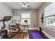 Bright home office featuring a desk, modern stationary bike, and natural light from a large window at 5829 Broadway St, Indianapolis, IN 46220