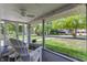 Inviting screened in patio with comfortable seating and a view of the front yard and street at 5829 Broadway St, Indianapolis, IN 46220