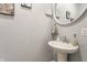 A clean, bright powder room with a pedestal sink and stylish decorations at 5829 Broadway St, Indianapolis, IN 46220