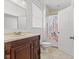 Bathroom features a vanity with dark wood cabinets and a shower with leaf patterned curtain at 608 East 21St St, Indianapolis, IN 46202