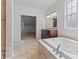 Bathroom showcasing a soaking tub, double vanity, and a view of an adjacent room at 608 East 21St St, Indianapolis, IN 46202
