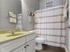 Charming bathroom with a white vanity, red striped shower curtain and wooden floors at 6150 Rolling Rock Ln, Noblesville, IN 46062