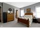 Well-lit bedroom featuring wood furnishings, carpeted floor, and decor art at 6150 Rolling Rock Ln, Noblesville, IN 46062