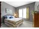 Comfortable bedroom featuring cozy bedding and a sunlit window with floral curtains at 6150 Rolling Rock Ln, Noblesville, IN 46062