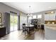 Bright dining area with a dark round table, decorative curtains, and sliding door access to the outdoors at 6150 Rolling Rock Ln, Noblesville, IN 46062