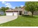 Charming home featuring a stone facade, red siding, two-car garage, and beautifully manicured lawn at 6150 Rolling Rock Ln, Noblesville, IN 46062