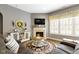 Inviting living room featuring a decorative fireplace, a comfortable couch, and ample natural light at 6150 Rolling Rock Ln, Noblesville, IN 46062