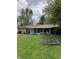 Large backyard featuring a fire pit and direct access to sunroom and backyard patio at 6430 E Stop 11 Rd, Indianapolis, IN 46237