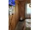 Cozy bedroom featuring knotty pine, side window with sheers, and a comfortable bed at 6430 E Stop 11 Rd, Indianapolis, IN 46237