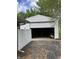 Detached garage with white vinyl siding, and an open garage door at 6430 E Stop 11 Rd, Indianapolis, IN 46237