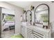 Bathroom with double vanity, black framed oval mirrors, and green tile flooring at 6464 Whitley Ln, Indianapolis, IN 46260