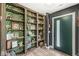 Unique entryway with a bold green accent door and custom shelves filled with vintage decor at 6464 Whitley Ln, Indianapolis, IN 46260