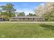 Well-maintained single-story home with a stone facade, black fence, and manicured lawn, ready to move in at 6464 Whitley Ln, Indianapolis, IN 46260
