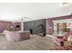 Spacious living room featuring a stone fireplace, ceiling fans and wood flooring at 6464 Whitley Ln, Indianapolis, IN 46260