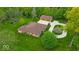 Aerial view of a house with a well-manicured lawn, a long driveway, and a detached garage at 6465 Lawrence Dr, Indianapolis, IN 46226