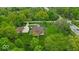 Aerial view of a property featuring mature trees, a winding driveway, and a well-maintained lawn at 6465 Lawrence Dr, Indianapolis, IN 46226