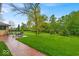 Expansive backyard featuring a large lawn with mature trees and brick paver patio with seating at 6465 Lawrence Dr, Indianapolis, IN 46226