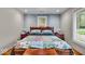 Cozy bedroom featuring a wooden headboard, colorful quilt, and natural light from the window at 6465 Lawrence Dr, Indianapolis, IN 46226