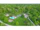 Aerial view featuring a pool, tennis court, playground, manicured lawns, and stately home at 6465 Lawrence Dr, Indianapolis, IN 46226
