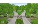 Grand entrance to a luxurious estate featuring an iron gate and mature trees lining the drive at 6465 Lawrence Dr, Indianapolis, IN 46226