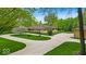 An impressive single story home with circle drive and extensive concrete parking area on a landscaped lawn at 6465 Lawrence Dr, Indianapolis, IN 46226