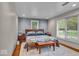 A relaxing main bedroom with textured accent wall, hardwood floors and a large window with backyard views at 6465 Lawrence Dr, Indianapolis, IN 46226