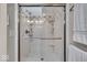 Bathroom shower features a glass door, white tile, overhead lighting, and a mounted showerhead at 6465 Lawrence Dr, Indianapolis, IN 46226