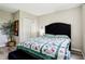 Comfortable bedroom includes a large black tufted bed, side table, and light floors at 7045 Gavin Dr, Indianapolis, IN 46217