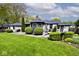 Spacious backyard with lush lawn, manicured greenery, and a large back patio at 7245 Highburry Dr, Indianapolis, IN 46256