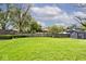 Large grassy backyard with a fence, shed, and surrounding mature trees at 7245 Highburry Dr, Indianapolis, IN 46256