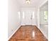 Bright entryway featuring hardwood floors and a white front door with sidelights at 7245 Highburry Dr, Indianapolis, IN 46256