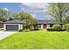Charming ranch home with a well-manicured lawn, bright red door and attached garage at 7245 Highburry Dr, Indianapolis, IN 46256