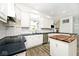 Open kitchen with white cabinets, stainless steel appliances, black countertops, and a wooden island at 7245 Highburry Dr, Indianapolis, IN 46256