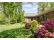 Beautiful backyard with green lawn, flowering bushes, and a brick home exterior at 7420 Denton Cir, Indianapolis, IN 46256
