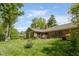 A beautifully landscaped backyard with a brick home, outdoor dining set, and lush green lawn at 7420 Denton Cir, Indianapolis, IN 46256