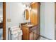 Bathroom featuring wooden vanity with granite countertop, oval mirror, and decorative lighting at 7420 Denton Cir, Indianapolis, IN 46256