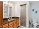 Bathroom with a framed mirror, wooden vanity with drawers, and a glass shower door at 7420 Denton Cir, Indianapolis, IN 46256