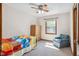 Bright bedroom with ceiling fan, a window, and a comfortable armchair at 7420 Denton Cir, Indianapolis, IN 46256