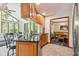 Open kitchen with granite counters, tiled floor, wood cabinets, and an adjacent breakfast nook with abundant natural light at 7420 Denton Cir, Indianapolis, IN 46256