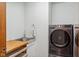 Modern laundry room with stainless steel washer and dryer, sink, and wood countertop at 7420 Denton Cir, Indianapolis, IN 46256