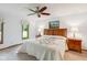Bright bedroom with neutral walls, warm ceiling fan, and warm wooden furniture at 7420 Denton Cir, Indianapolis, IN 46256