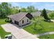 Overhead view of brick home featuring a large driveway and lush lawns at 7665 Stones River Ct, Indianapolis, IN 46259